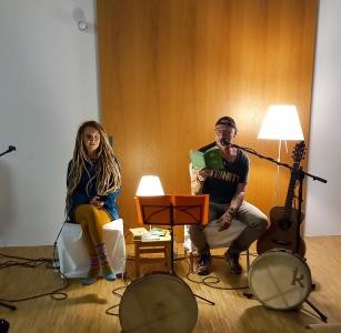 Klaus Zeh und Adeline sitzen zusammen in einem Raum mit Mikrofon und einem Buch
