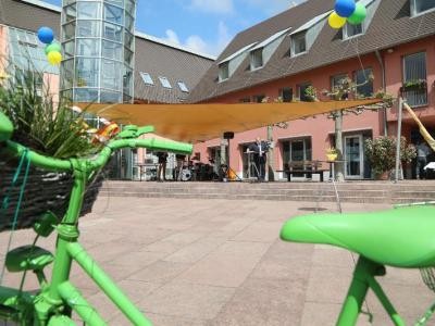 Grünes Rad mit Blumen und Luftballons Blick auf das Rathaus