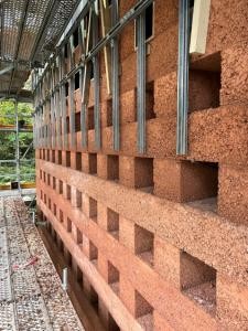 Rote Stampfbetonfassade am Turm