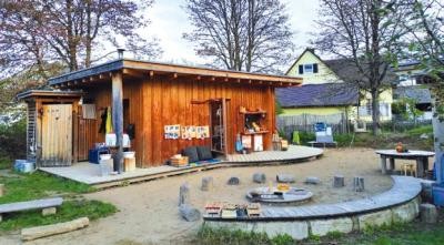 Das Foto zeigt ein überdachtes Holzhaus das als Werkbereich genutzt wird.