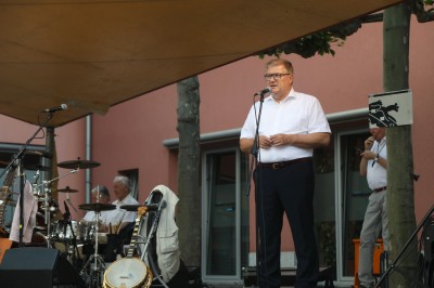 Joachim Schuster auf der Bühne mit Mikrofon auf dem Rathausplatz