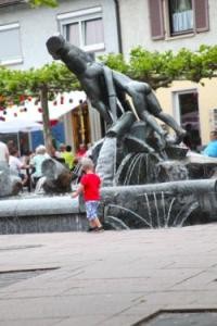 Brunnen auf dem Rathausplatz mit spielendem Kind