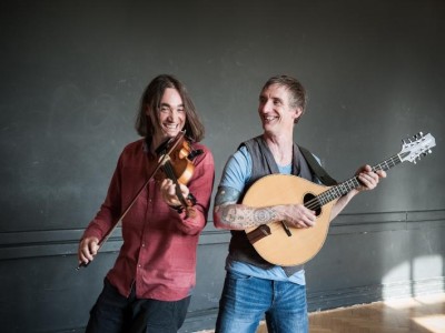 zwei Männer spielen Geige und Gitarre