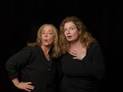 Zwei Frauen in dunkler Klaidung vor dunklem Hintergrund