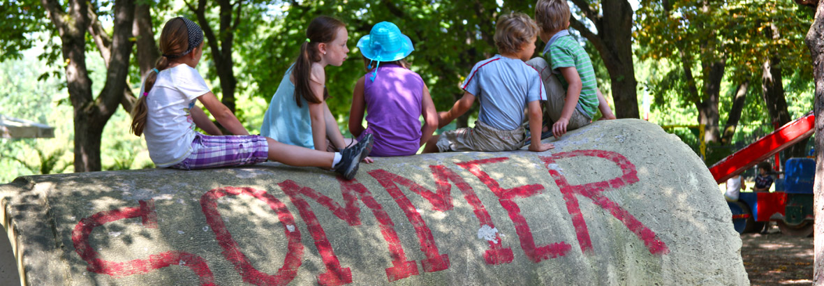 Fünf Kinder sitzen auf einer großen Heurolle  
