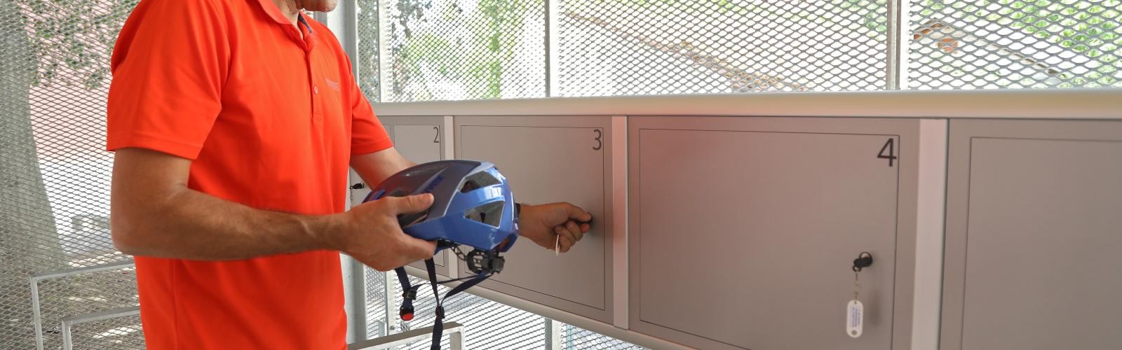 Mann schließt Helm in Schließfach ein