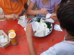 Drei Kinder bereiten auf einem Teller einen Quark zu.